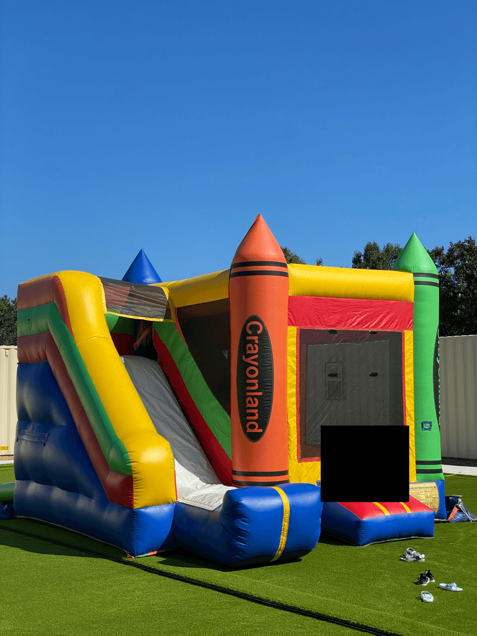 A colorful Crayonland inflatable with slide and bounce area.