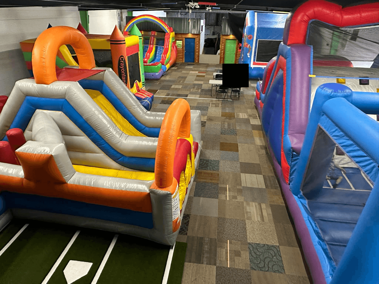 An inside view of multiple inflatables set up at the Grand Bounce facility.
