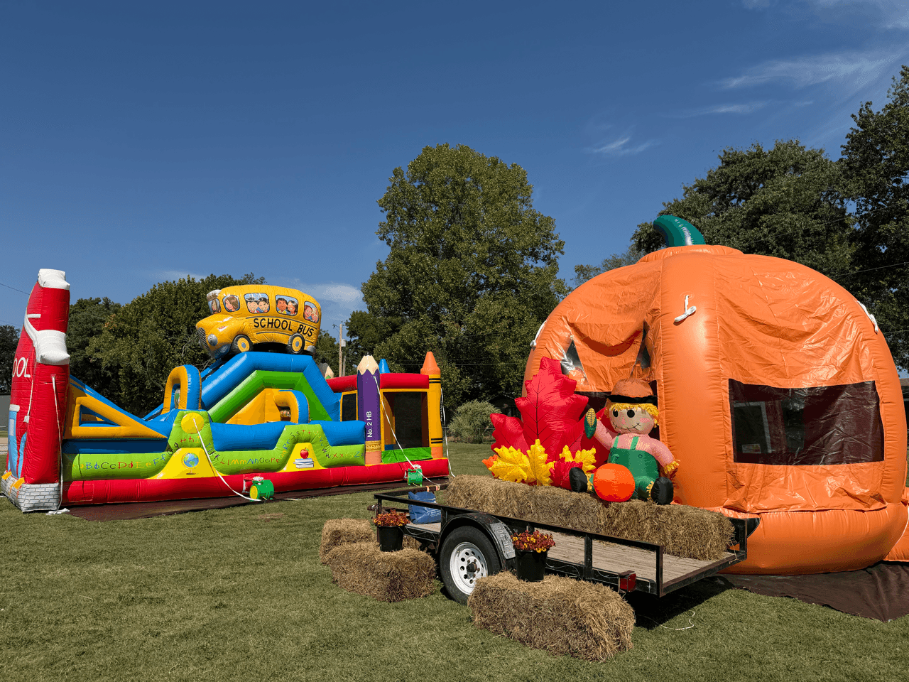 An outdoor fall-themed inflatable scene with hay bales.