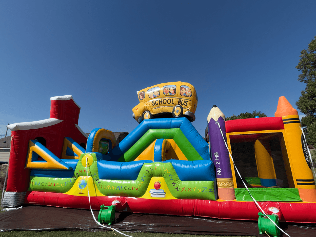 A school bus themed inflatable with multiple play zones.