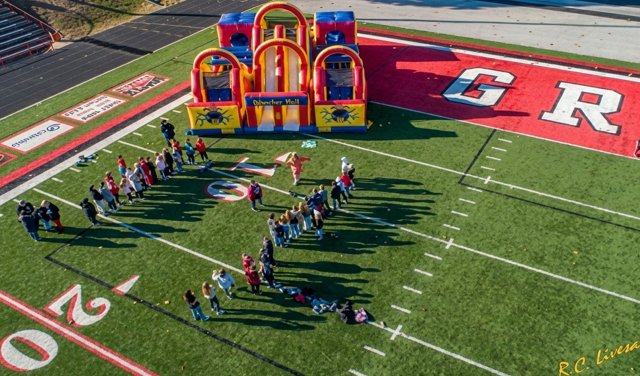 A community event with an inflatable and a group gathered outside.