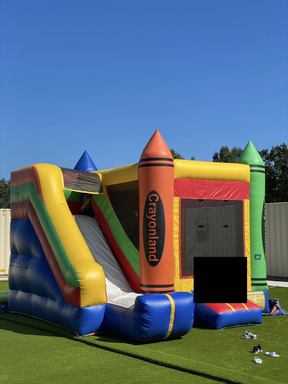 A colorful Crayonland inflatable with slide and bounce area.