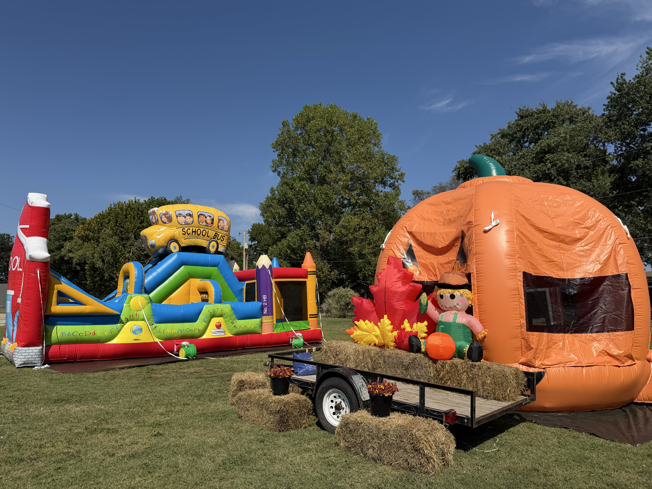 An outdoor fall-themed inflatable scene with hay bales.