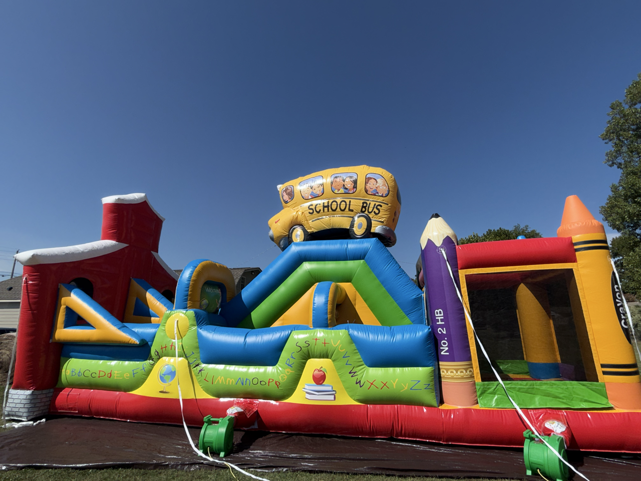 A school bus themed inflatable with multiple play zones.